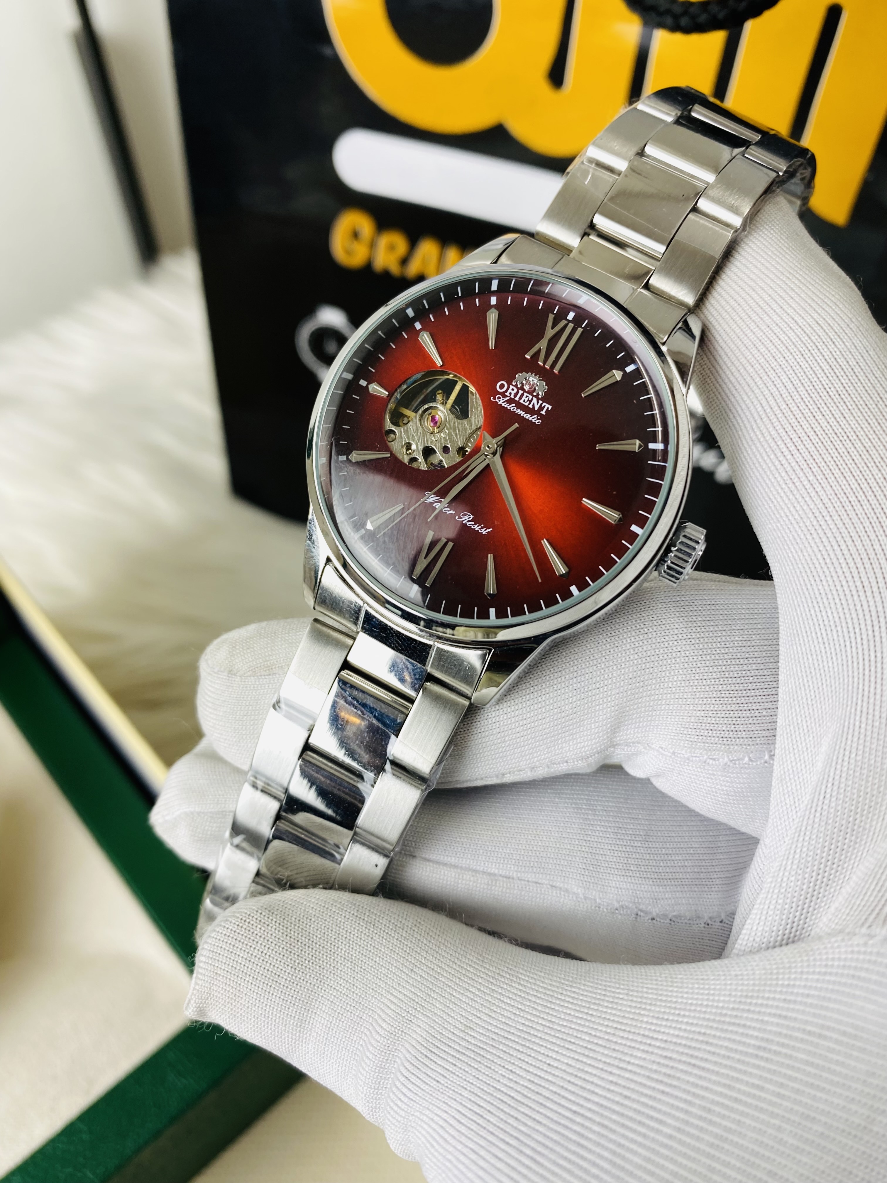 Orient Bambino Open Heart automatic men's watch with a red dial and a stainless steel bracelet._img_2